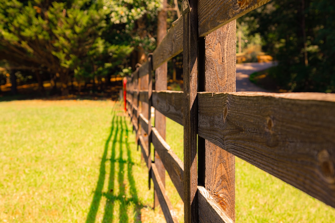 brown-wooden-fence-on-green-grass-field-during-daytime-mzrcugn3mpe